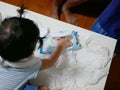 Curious Asian baby girl`s hand pulling out baby wipes all over the table